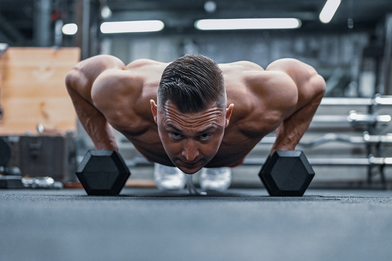 Man doing push-ups on dumbells - Dope Uncle