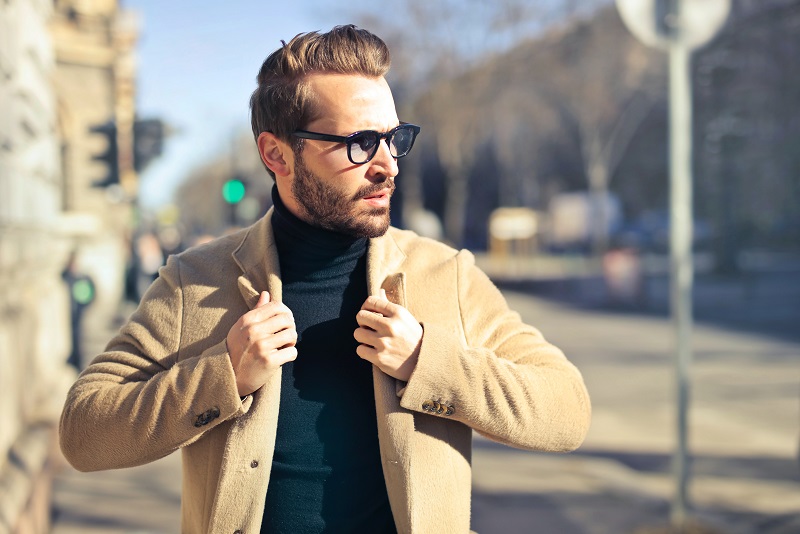 Man in brown jacket and black polo neck